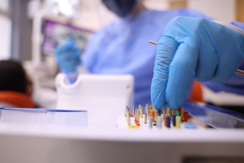 Detailed shot of a dentist selecting dental tools for a procedure in a clinic.