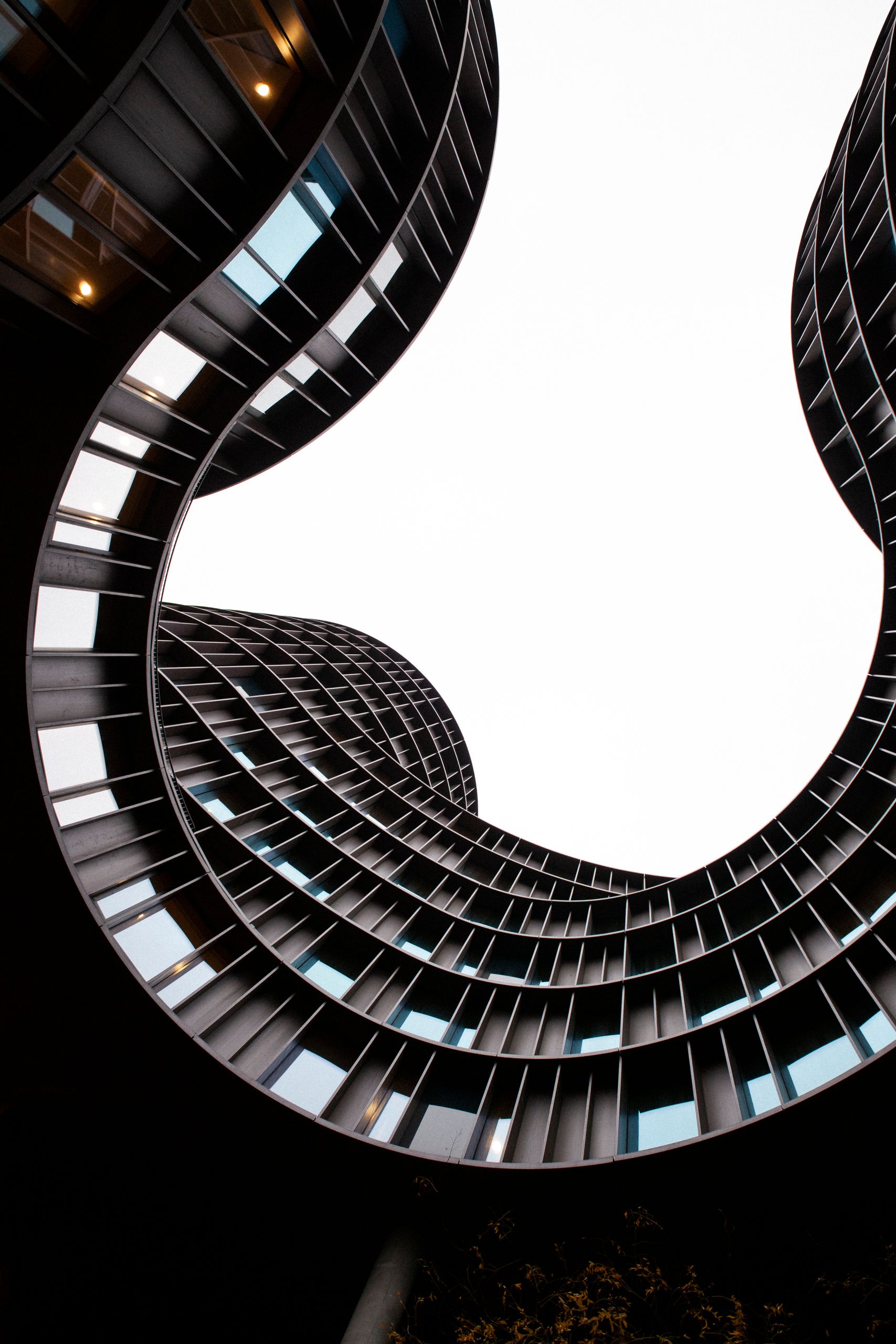 View of modern glass buildings curving toward the sky in Copenhagen, Denmark.